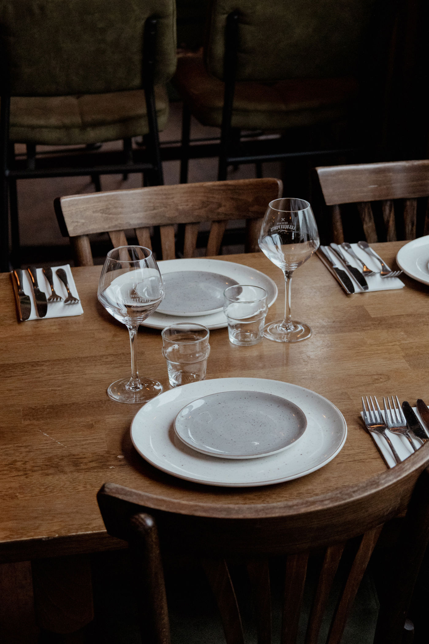 Restaurant interieur Les Deux Ponts Gedekte tafel met wijnglazen, borden en bestek Restaurant interieur Les Deux Ponts Gedekte tafel met wijnglazen, borden en bestek