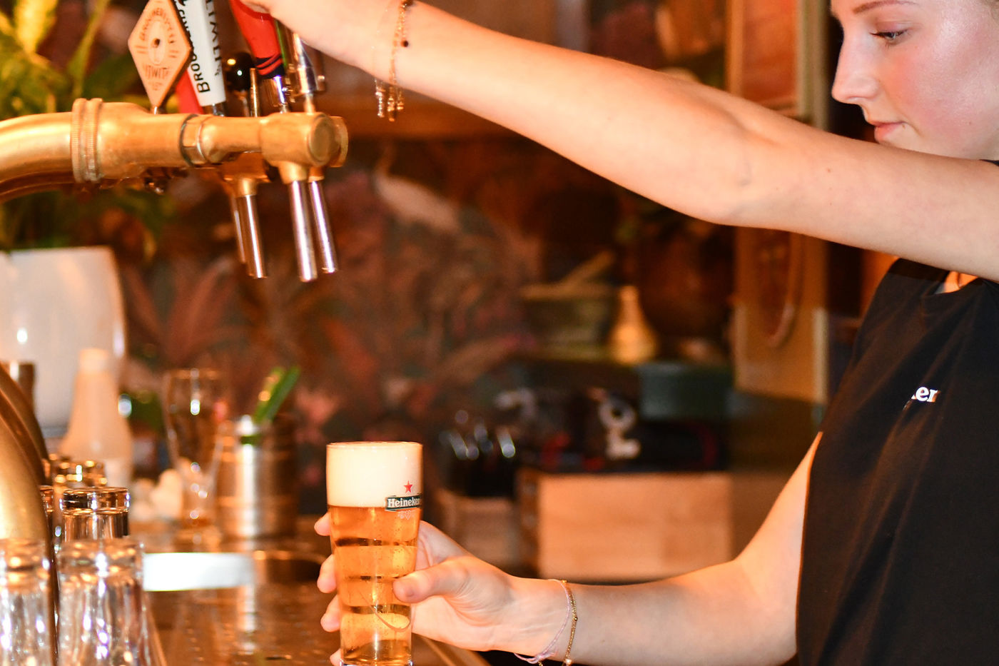 Les Deux Ponts barvrouw tapt biertje aan de bar Les Deux Ponts barvrouw tapt biertje aan de bar