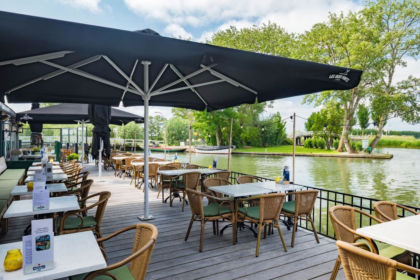 Terras aan het water onder grote parasol bij Restaurant Les Deux Ponts Terras aan het water onder grote parasol bij Restaurant Les Deux Ponts